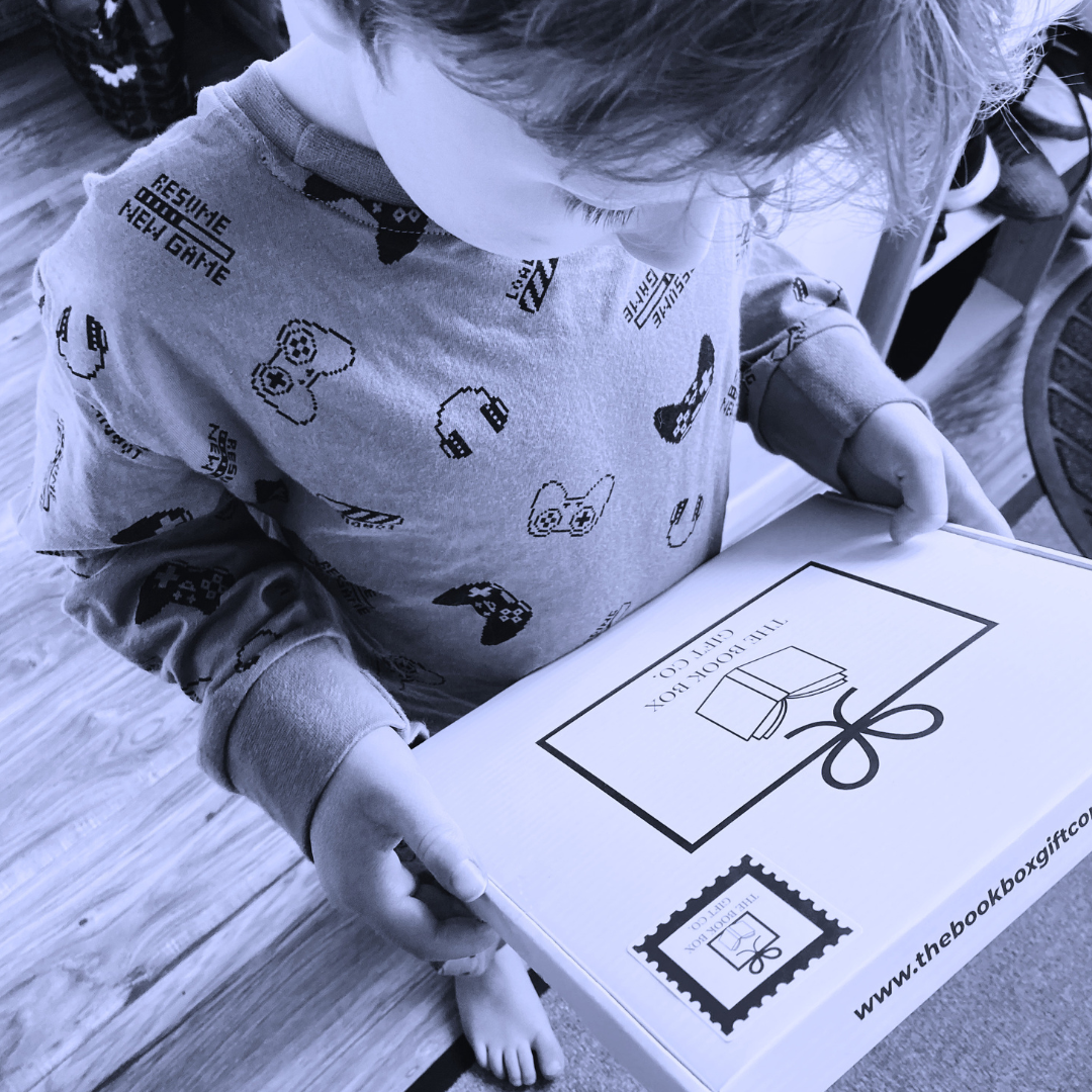 Child receiving their monthly book subscription or book gift in box with extra treats.